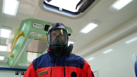Standing paramedic with the gasmask in the ambulance