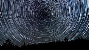 Stars move around a polar star. Time lapse of Star trails in the night sky. 4K - Powered by Shutterstock - Get 15% off with code: PIKWIZARD15