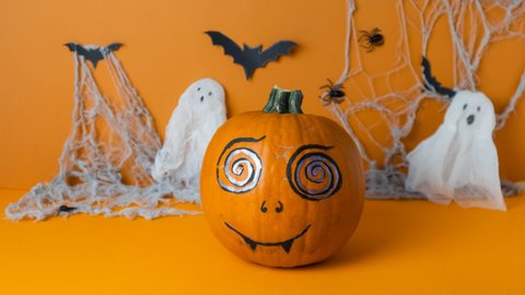painted pumpkin spins around itself and changes facial expression, stop motion video for halloween, happy halloween concept