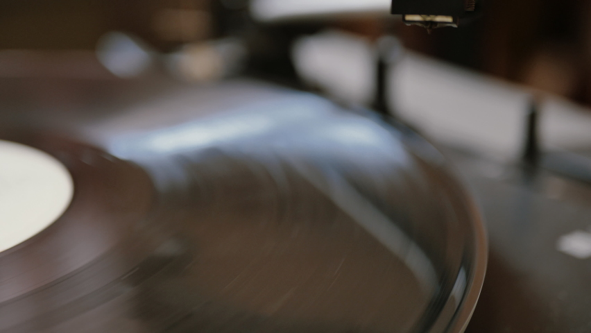 hands placing the vintage turntable on a spinning vinyl record. the vinyl record is spinning. the needle plays on a vintage vinyl record Royalty-Free Stock Footage #1059588209