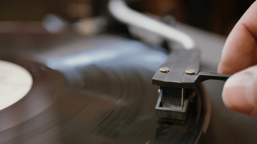 Hands placing the vintage turntable on a spinning vinyl record. the vinyl record is spinning. the needle plays on a vintage vinyl record | Shutterstock HD Video #1059588209