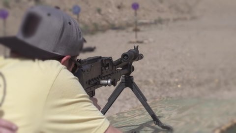 A man shooting a machine gun 