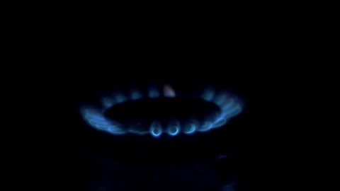 Kitchen burner turning on.Stove top burner igniting into a blue cooking flame. Natural gas inflammation, close up