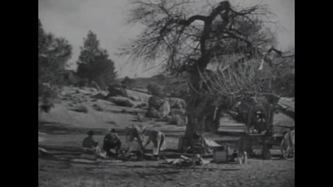 CIRCA 1937 - In this western film, a stuttering cook serves a campfire lunch to Hopalong Cassidy and his sidekick (Gabby Hayes).