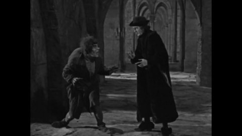 CIRCA 1923 - In this silent movie adaptation of the Hunchback of Notre Dame, Quasimodo jeers at Jehan and is treated kindly by the archdeacon.