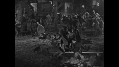 CIRCA 1923 - In this silent movie adaptation of the Hunchback of Notre Dame, Clopin leads a mob out of the Court of Miracles to save Esmeralda.
