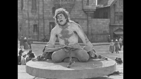CIRCA 1923 - In this silent movie adaptation of the Hunchback of Notre Dame, Quasimodo is taunted by his tormentors when he asks for water.