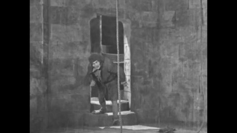CIRCA 1923 - In this silent movie adaptation of the Hunchback of Notre Dame, Quasimodo (Lon Chaney) rings the cathedral's bells.
