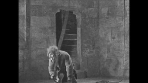 CIRCA 1923 - In this silent movie adaptation of the Hunchback of Notre Dame, Quasimodo rings the bells as Esmeralda is brought to the gallows.