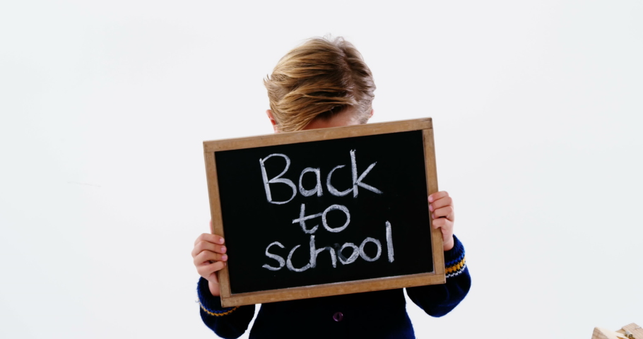 Animation of mathematical equations floating over schoolchild holding board with text Back To School with coloured pencils in the background Education back to school concept digitally generated image.