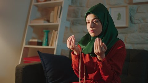 Muslim woman praying to god after salat at home.