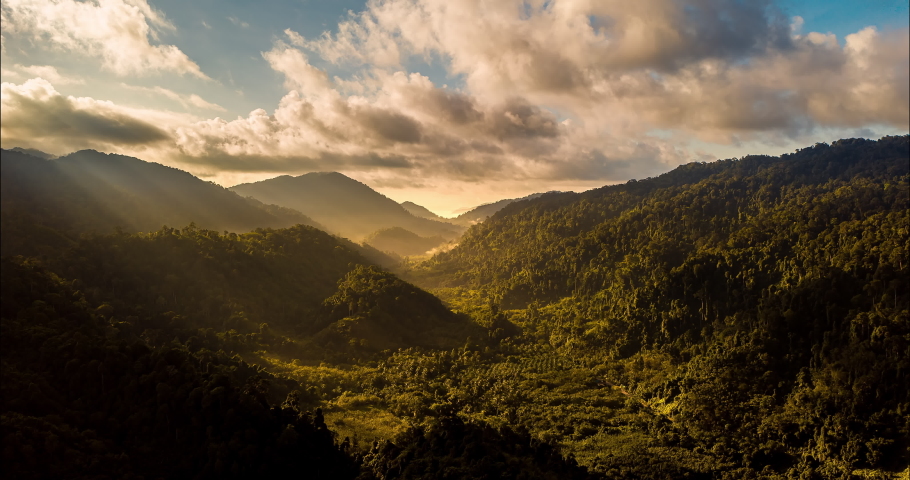 Aerial drone hyperlapse timelapse of beautiful tropical valley between mountains. The first rays of the rising sun break through the clouds and clouds. The last rays of the sunset hit the tree crowns. | Shutterstock HD Video #1059635909