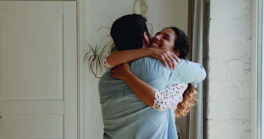 After long separation loving 35s couple reunited, wife and husband missed very much go to meet each other hugging standing indoor feeling deep love and happiness. Love and long-awaited meeting concept | Shutterstock HD Video #1059636410