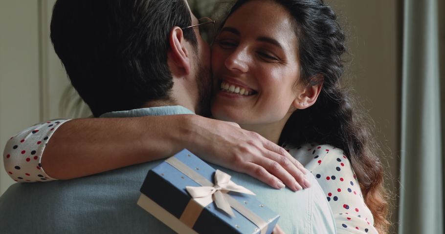Rear view husband hugs wife makes surprise. Close up face happy female cuddles beloved man hold giftbox express gratitude for gift at 8-march International Women Day, life events celebrations concept | Shutterstock HD Video #1059636452