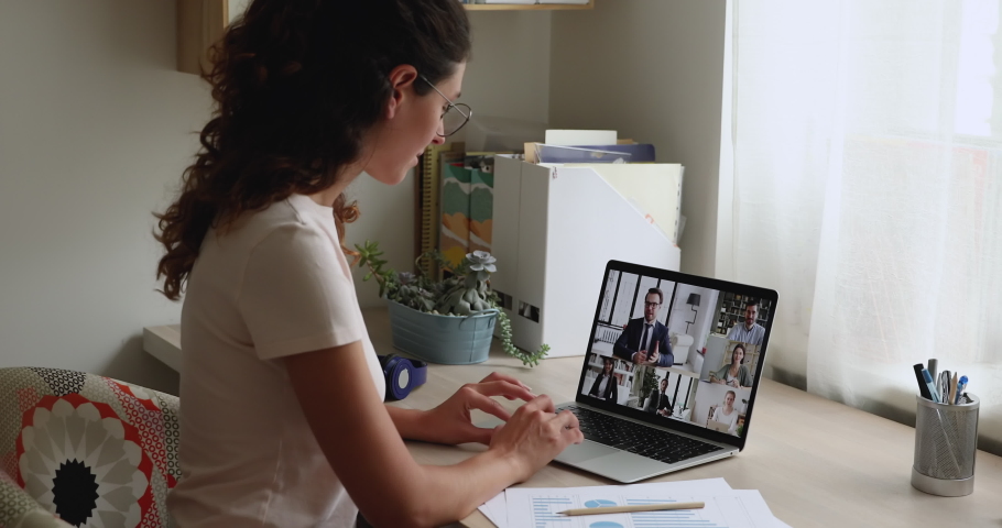 Staff engaged in video conference virtual meeting, female talking to colleagues remotely sit at desk look at laptop screen where group of people involved in briefing by video call. Modern tech concept Royalty-Free Stock Footage #1059650114