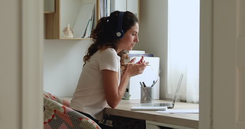 Woman sit at desk wear headphones gain new knowledge using video call laptop and services of e-teacher. Advanced training, learning foreign language remotely, modern tech and internet connection usage