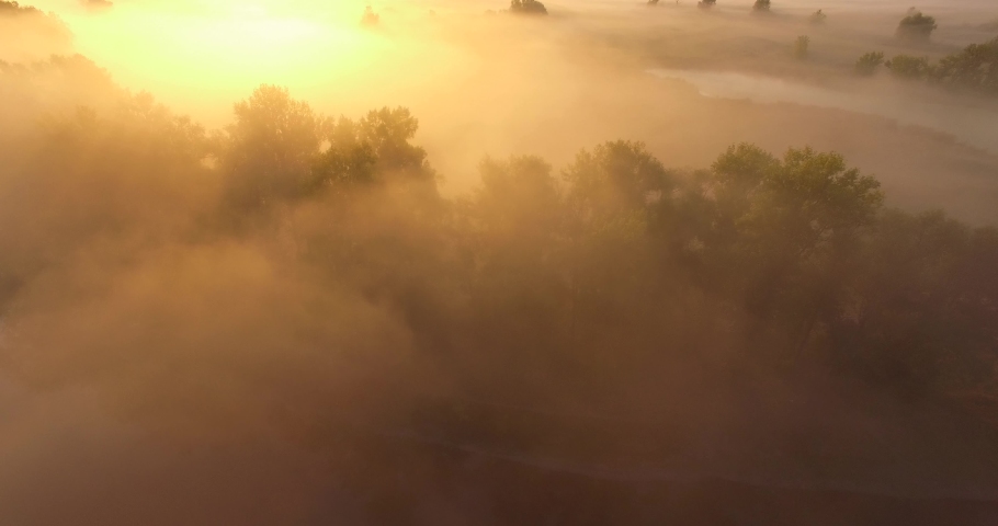 Aerial view of pink sunrise on misty valley of Siverskyi Donets river near Zmiiv city, Ukraine. Sideways camera movement