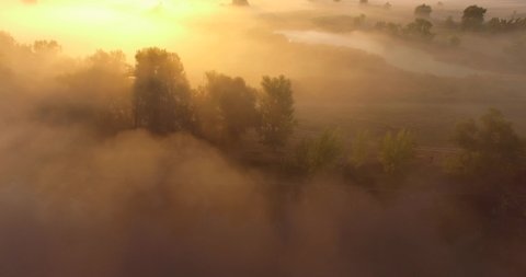 Aerial view of pink sunrise on misty valley of Siverskyi Donets river near Zmiiv city, Ukraine. Sideways camera movement