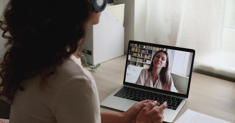 Women chatting by video conference call, laptop screen view over female shoulder. Convenient modern technology usage, personal or business communication remotely. Video call event interaction concept Royalty-Free Stock Footage #1059665720