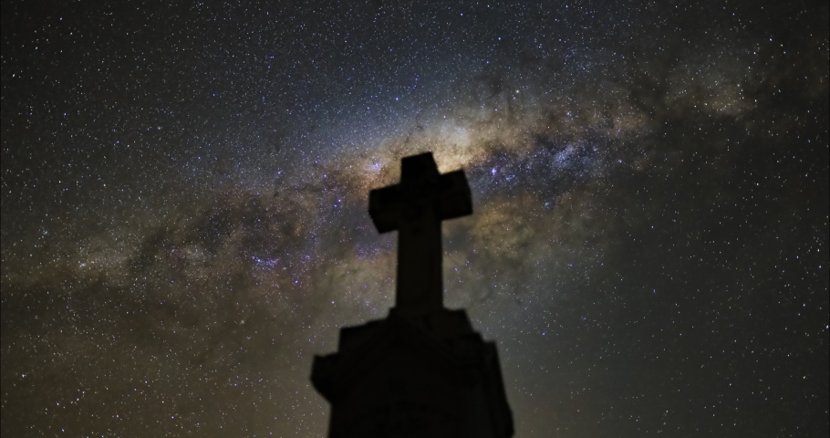 Graveyard tombstone with milky way galaxy night timelapse. Superstition, religious, heavenly and religious symbolism.