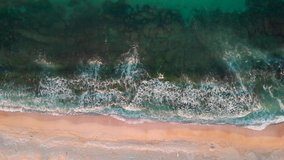 Top down drone video on waves at sunrise at the beach