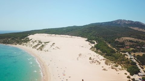 Aerial drone view of Natural Park of the Gibraltar Strait - Tarifa city CADIZ. View of Bolonia Sand Dune. Famous tourist destination in South of Spain. Costa de Luz. Drone going up and left rotation
