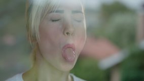 Pretty woman with blond hair has fun making binoculars using her hands near the window. There is a reflection of the scenery in the glass. - Powered by Shutterstock - Get 15% off with code: PIKWIZARD15