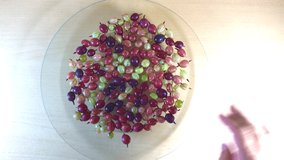 Macro shot HD video made of wild forest berries mixed composition made of grapes raspberry on glass tray buying now.