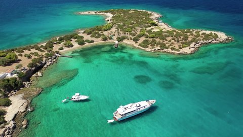 Aerial drone video of Hinitsa island bay a popular anchorage crystal clear turquoise sea bay for yachts and sailboats next to Porto Heli, Saronic gulf, Greece