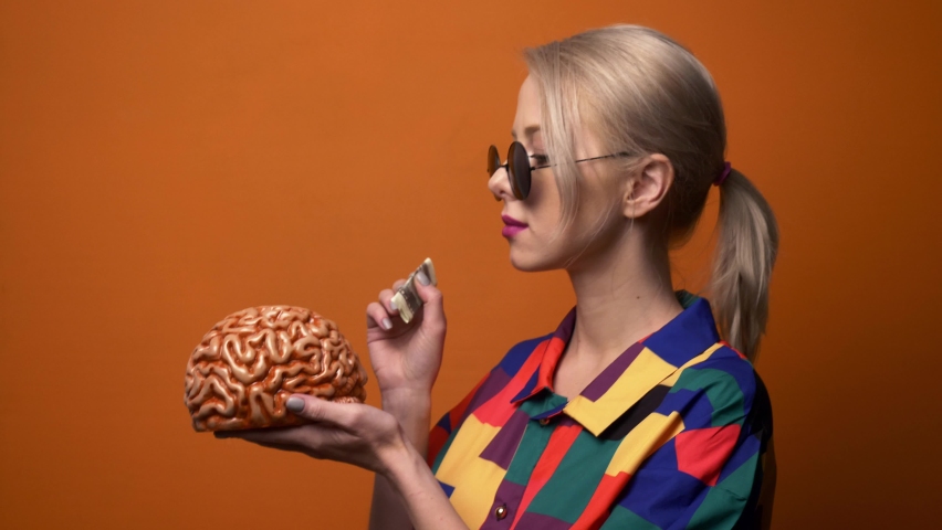 Style blonde in 90s shirt with human brain on orange background 