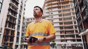 Construction worker with ear muff working at construction site. Worker puts on ear defenders to protect against sound. Taking care of health, safety at work. Earplugs. Too loud sound, hearing damage. - Powered by Shutterstock - Get 15% off with code: PIKWIZARD15