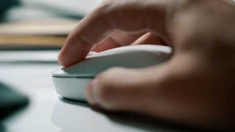 White computer mouse on a work desk. Working with a PC and click on the mouse. Footage of the workplace in 4K