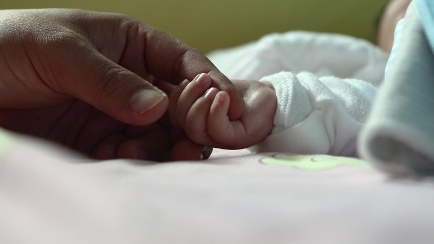 New born baby hand holding father hand during baby sleeping. newborn baby and dad hands. father taking care of her son kid happy family dream of health Royalty-Free Stock Footage #1059695963