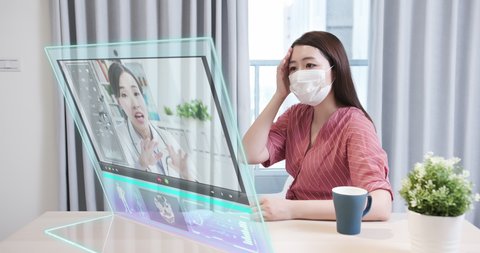 Telemedicine concept - In the near future asian female patient consult her health condition to doctor online by transparent display computer at home