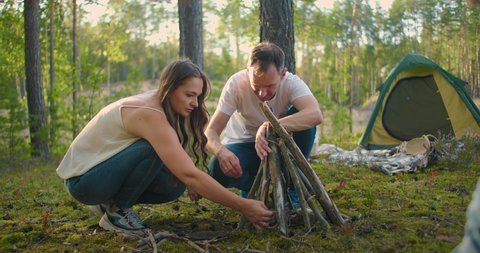 Families in nature together collect and install a fire for cooking. Family journey into the woods. Hike with a tent and an overnight stay in the woods by the fire: stockvideo