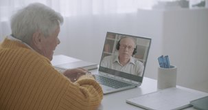 two old male friends are chatting remotely, using modern technology of communication, video call by laptop with internet