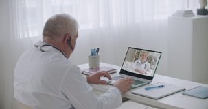 therapist and infectious diseases specialist are consulting each other by video call from offices in clinics, experience exchange