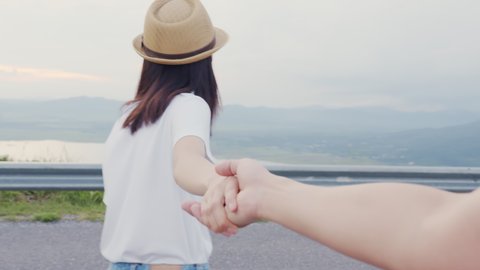 Young couple holding hands walking, the woman leading boyfriend to see the view. : vidéo de stock