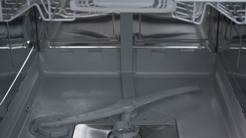 Inside dishwash machine. A view of a working dishwasher machine inside in the kitchen.