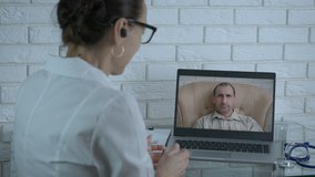 Medical consultation on computer screen. A man with influenza stay at home and speak on video call with a woman doctor.