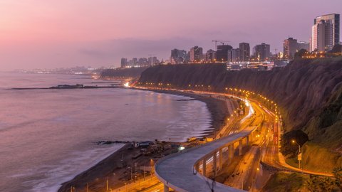 Aerial view of Lima's Coastline in the neighborhood of Miraflores day to night transition timelapse, Lima, Peru. Road traffic with junction and beach with ocean from Husares De Junin waterfront