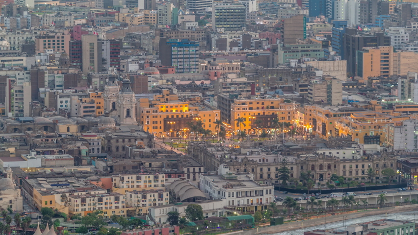 Aerial top view of Lima main square from San Cristobal hill day to night transition timelapse, government palace of Peru and cathedral church. People gathered at Plaza de Armas in the historic center