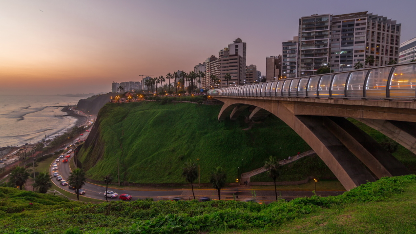 Villena Bridge with traffic and partial City view in the Background day to night transition timelapse, Lima, Peru. Aerial view with illuminated coastline and Love park