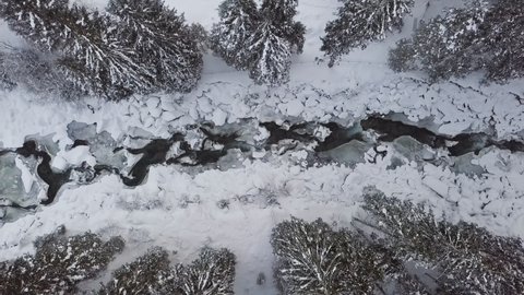 Overhead aerial view of winter forest and mountain river near Krimml Waterfalls, Land Salzburg, Austria.