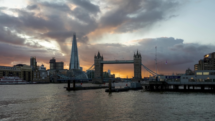 Day to night sunset time lapse view with impressive cloudscape in the sky to the Tower Bridge and modern skyline of London, United Kingdom
