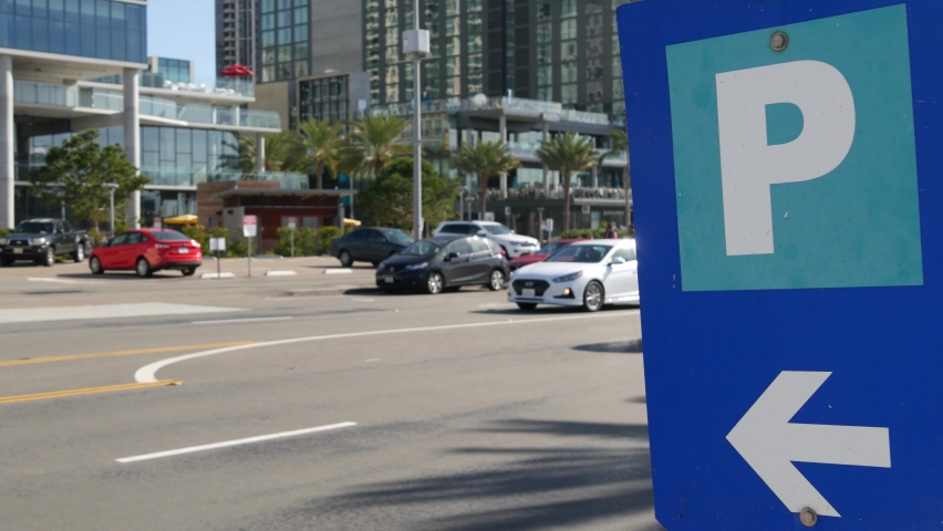 Parking lot sign as symbol of traffic difficulties and transportation issues in busy urban areas of USA. Public paid parking zone in downtown of San Diego, California. Limited space for cars in city.