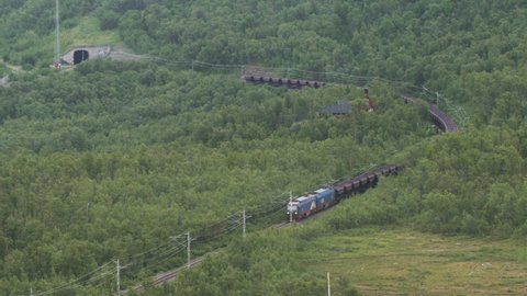 The Iron Ore Line In Northern Sweden. Time-lapse of a Moving Train Loaded With Iron Ore. Iron Industry, Natural Resources, Economy Concept. Location: Bjorkliden, Sweden, Scandinavia. July Of 2019. 