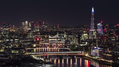 Establishing Aerial View Shot of London UK at night evening, amazing lights along the river, whole city skyline, United Kingdom
