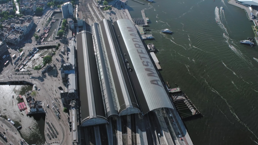 Aerial view of the IJ and the Amsterdam Centraal Station in Netherlands. Many ferries and cargo ships. 