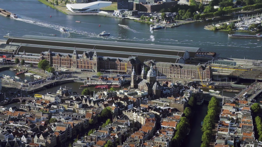 
Aerial view of the famous Amsterdam Centraal Station, the largest railway station in Netherlands. Many ferries in the IJ. 